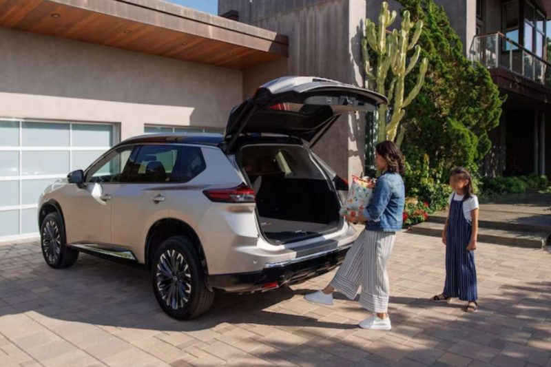 A woman and child loading items into the trunk of their 2024 Nissan Rogue SUV.