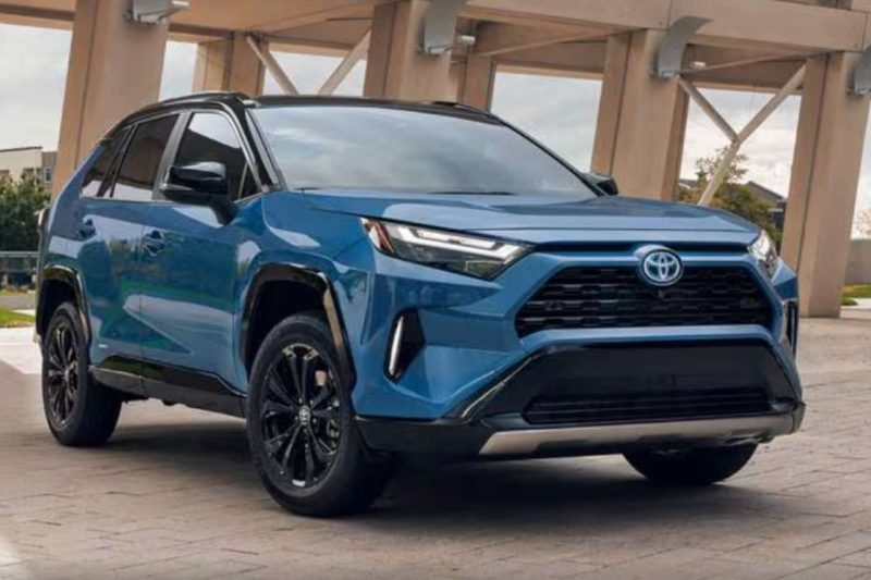 A 2024 Toyota RAV4 SUV in blue, parked under a concrete bridge.