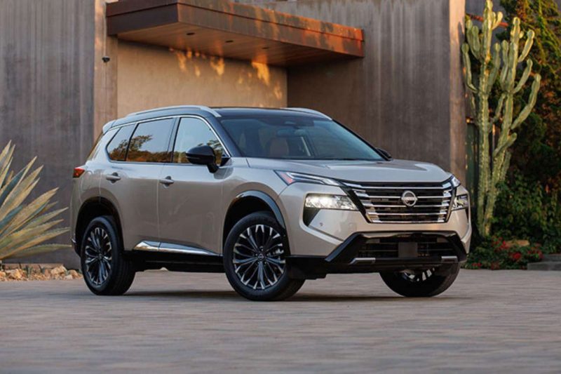 The new 2024 Nissan Rogue is parked outside a modern home in the sunlight.