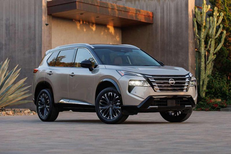 A Nissan Rogue SUV stands outside of a modern home.