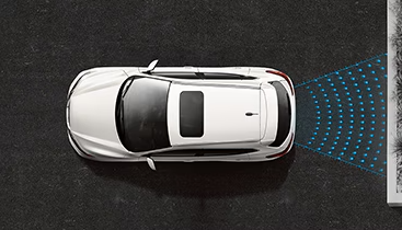 The Rear Braking System on a white Nissan vehicle, preventing the vehicle from backing into a stationary barrier.