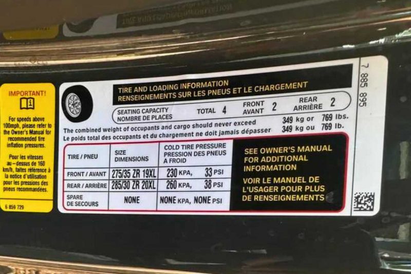 The tire pressure sticker on a car door jamb for car maintenance.