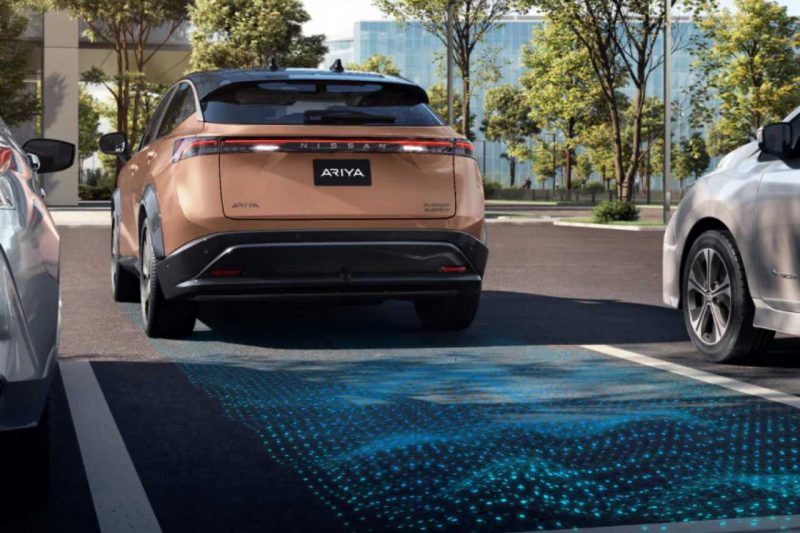 A Nissan Ariya SUV backs into a parking space using the Nissan Safety Shield 360 system.