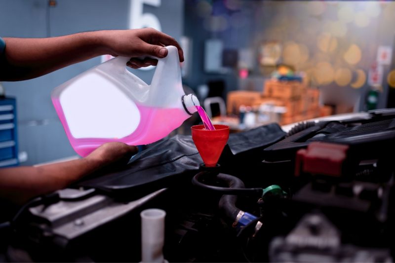 A mechanic adding new transmission fluid during a service appointment.