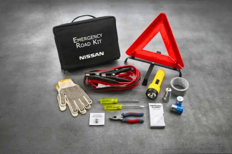 The contents of the Nissan Emergency Roadside Kit is displayed on a grey concrete floor.