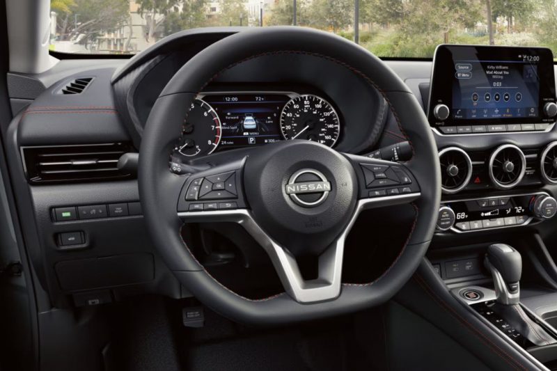 A close-up view at the Sentra's dashboard, including digital instruments, touchscreen, and heated steering wheel.