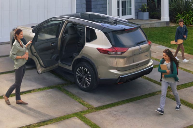 A family climbs into their 2025 Nissan Rogue, showcasing its spacy interior.
