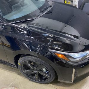 Dent on right front fender of black Nissan Sentra caused by bicycle.