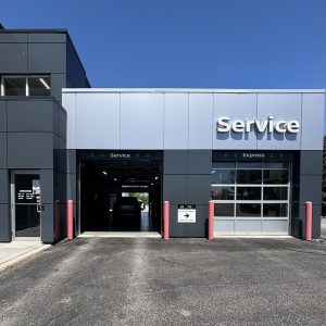 Picture of service drive-thru entrance at Nissan of Windsor with one overhead door open and one overhead door closed.