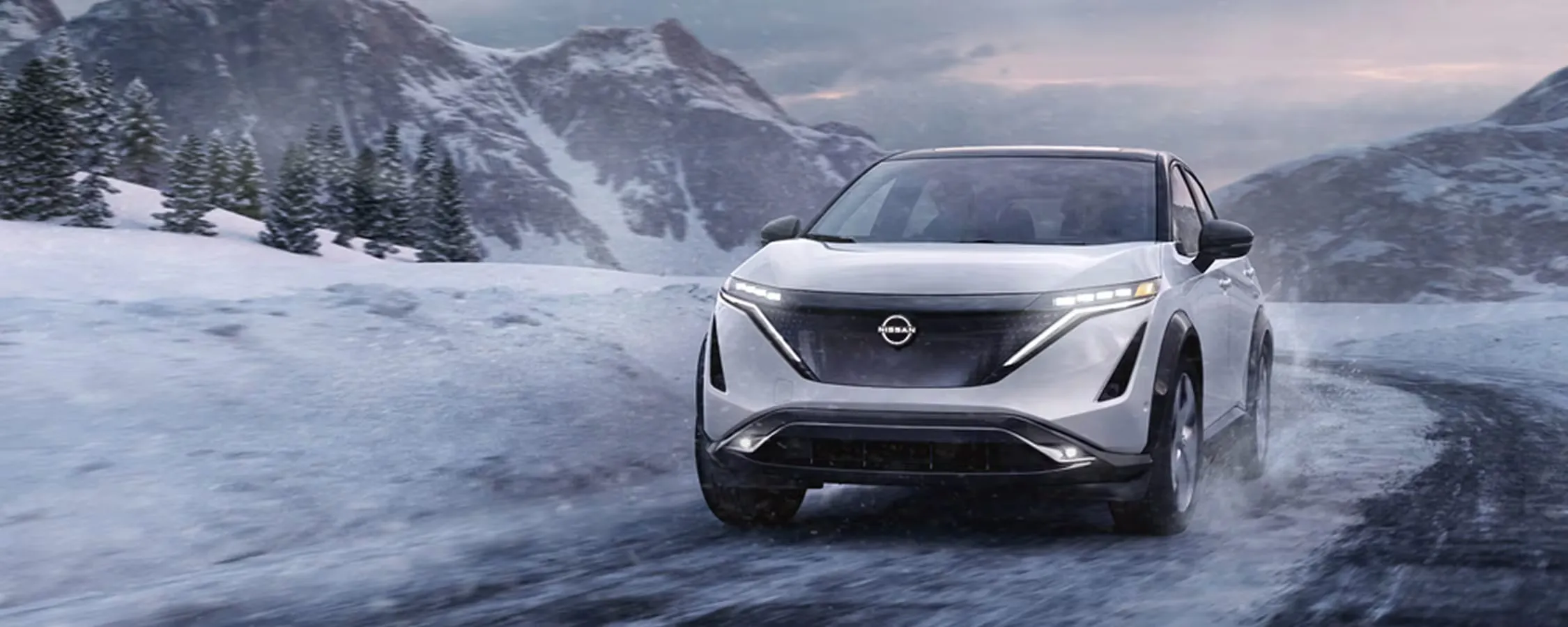 2026 Nissan Ariya driving on a snowy road to illustrate range and performance.