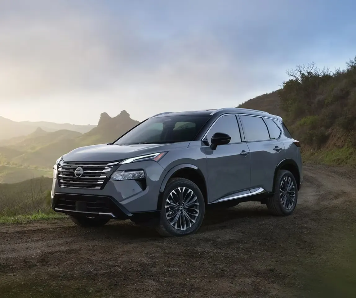 Nissan Rogue 2026 gris devant un paysage montagneux.