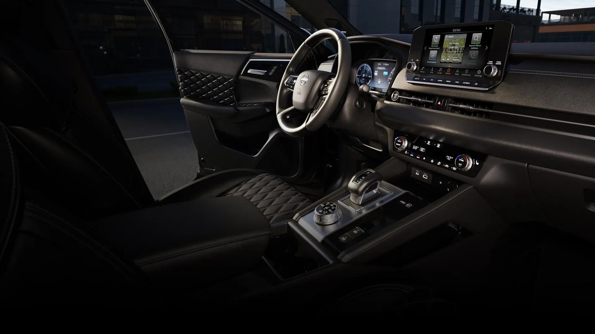 Habitacle du Nissan Rogue hybride rechargeable 2026 avec écran central et commandes de conduite. 