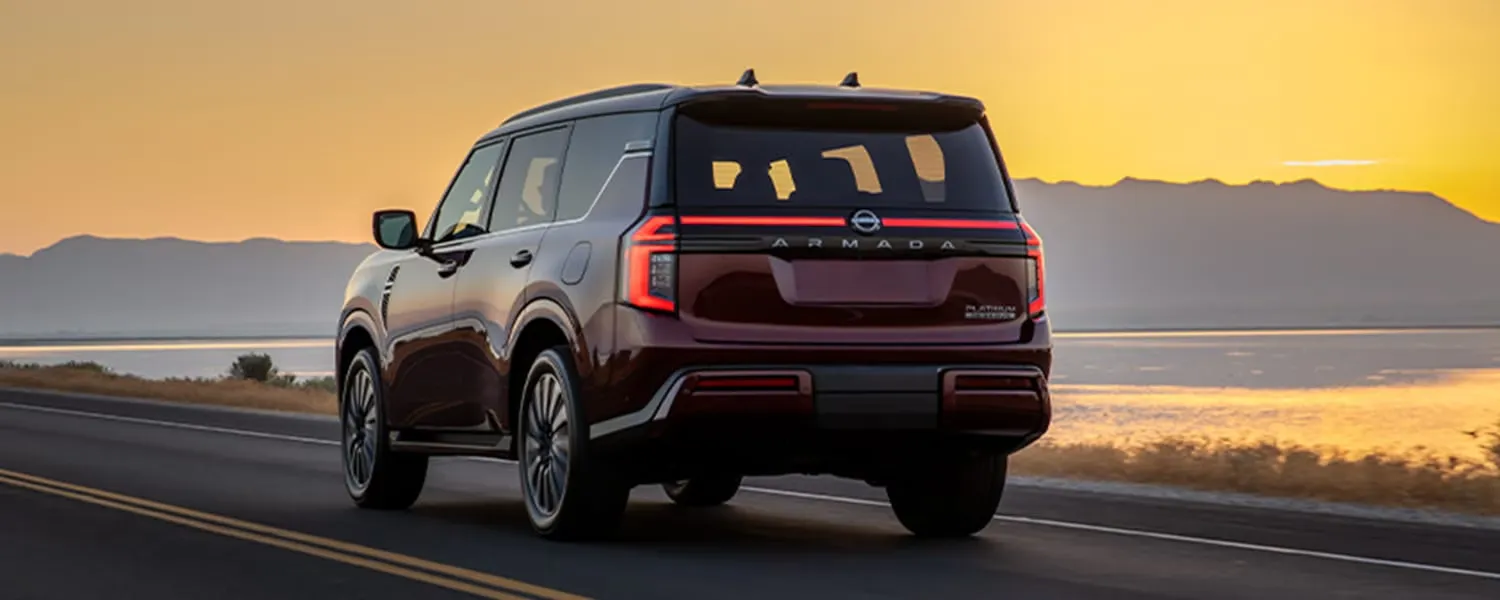 Burgundy 2026 Nissan Armada driving at sunset.