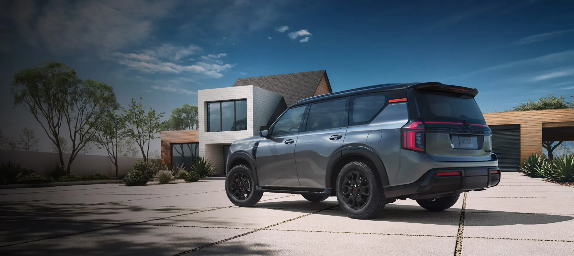 Grey 2026 Nissan Armada parked in front of a modern residence.