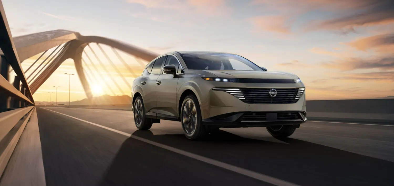 Exterior design of the 2026 Nissan Murano driving on a bridge at sunset.