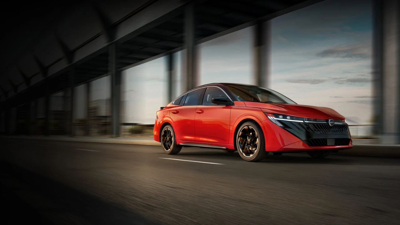 Nissan Sentra 2026 rouge roulant sous une structure urbaine.