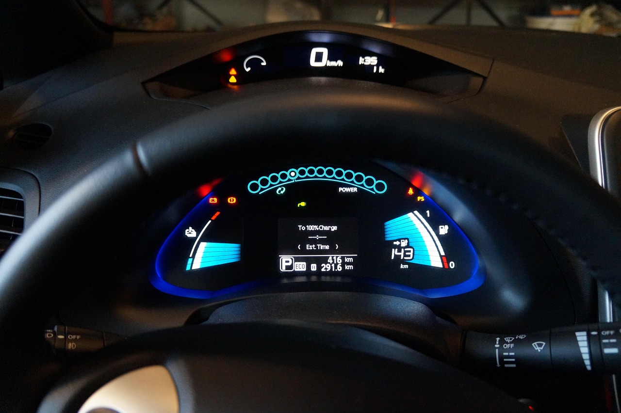 The image showcases the dashboard of the Nissan Leaf with advanced technology displays