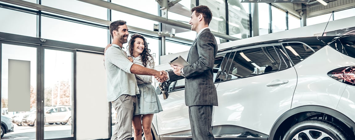 sales manager giving car keys to customers